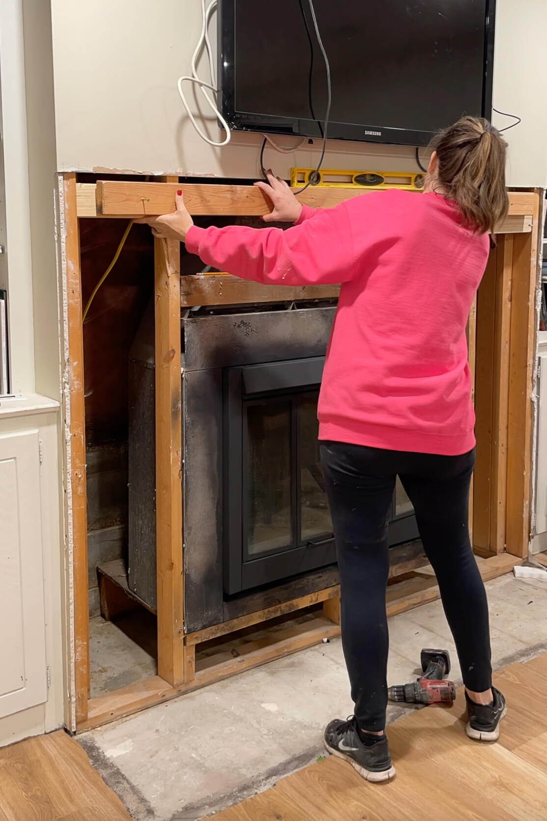 Installing extra blocking for installing a new fireplace mantle.